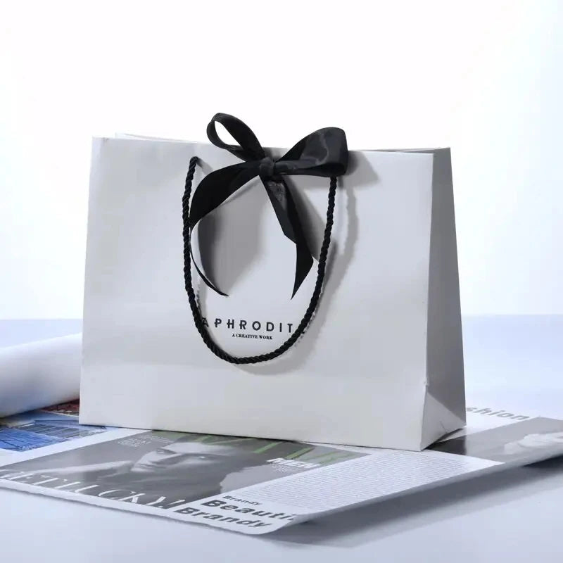 500pcs Wholesale Custom Logo Design Paper Bags | Luxury Ribbon Handle Gift Packaging for Cosmetics & Jewelry | High-Quality 250g Paperboard Shopping Bags Luxegan