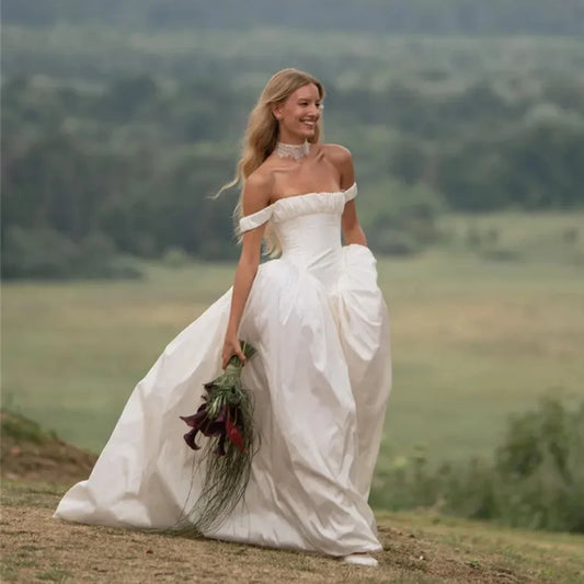 Vestido de novia de satén con hombros descubiertos, corsé estructurado y corte en A romántico, ideal para bodas al aire libre